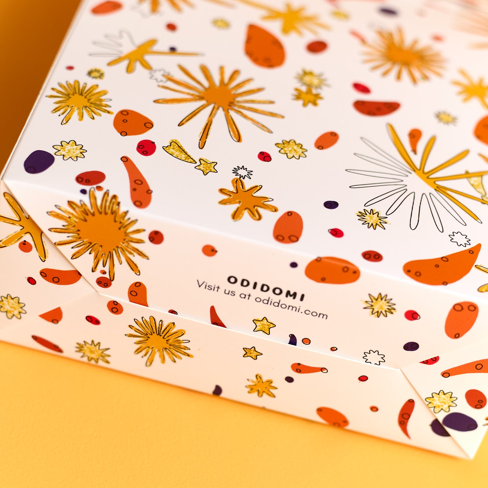 Close-up of ODIDOMI’s custom-designed packaging box featuring a festive, colorful pattern with gold foil details. The high-quality packaging reflects ODIDOMI’s commitment to beautifully curated goodie bags and creative party favors for kids' celebrations.