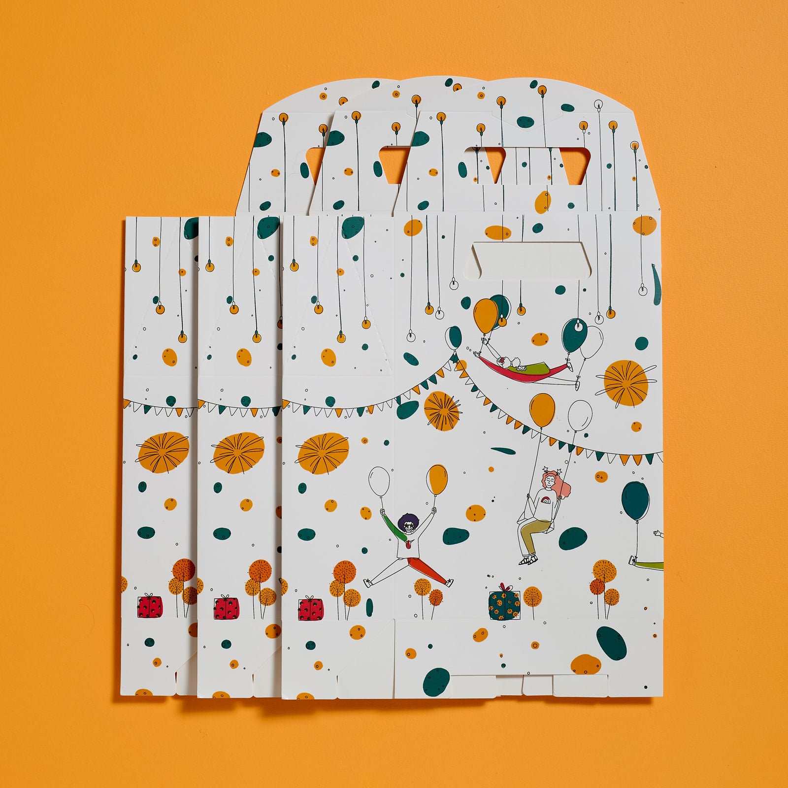 Flat lay of unfolded ODIDOMI goodie bags with a festive, illustrated design, displayed on an orange background. Designed in-house by ODIDOMI, a family-run brand crafting high-quality, handcrafted party favor bags for kids' celebrations.