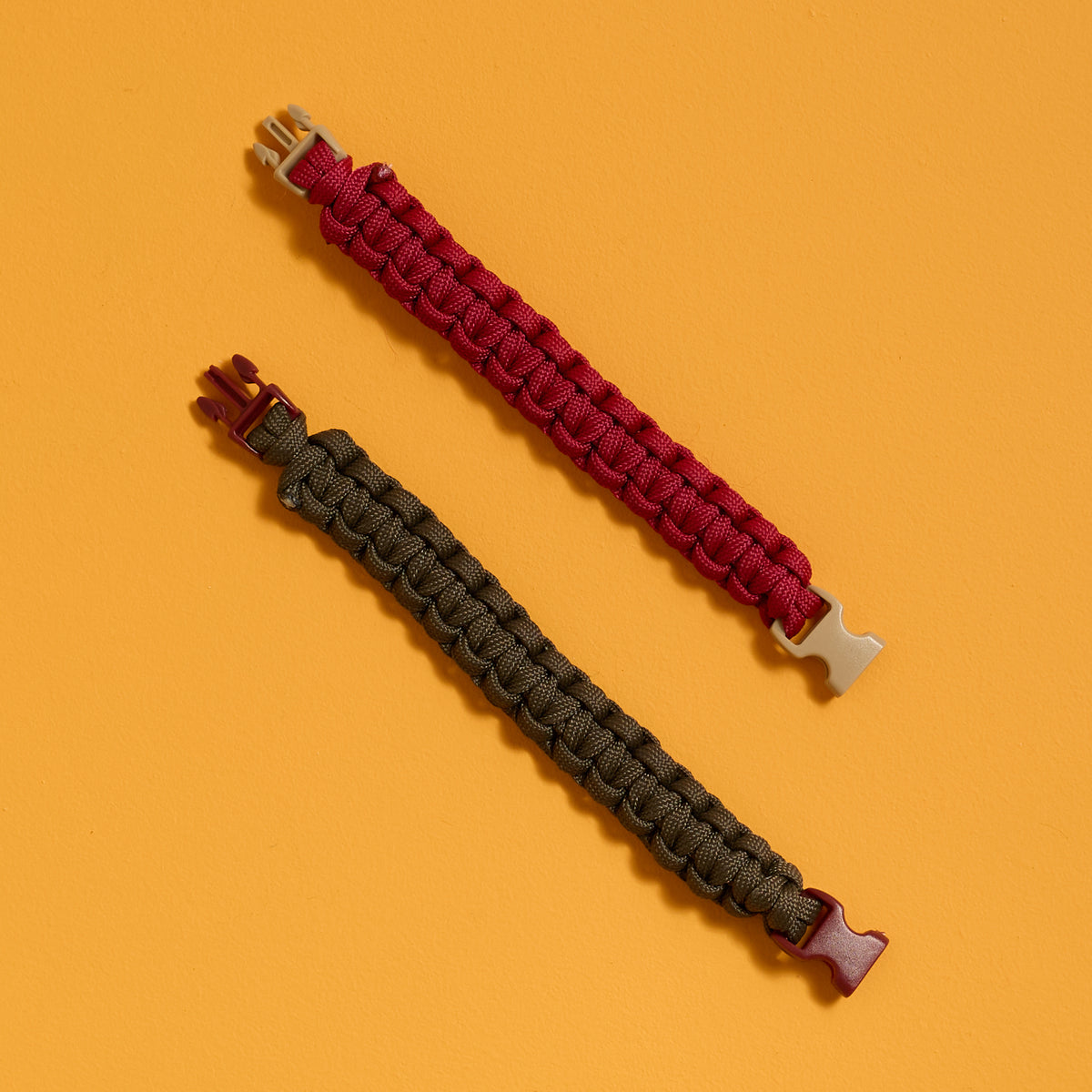 Flat view of finished bracelets from the ODIDOMI Adventure Bracelet Kit in charcoal and red.
