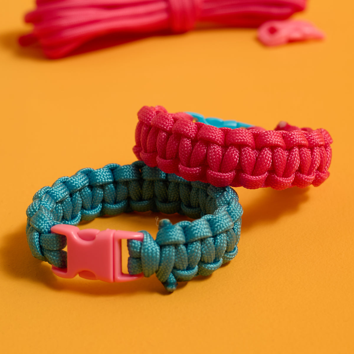 Close-up of finished buckled bracelets from the ODIDOMI Adventure Bracelet Kit in pink and blue.
