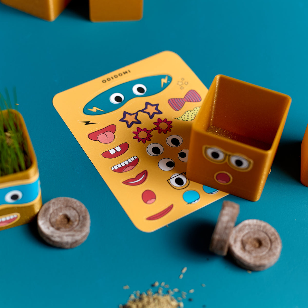 Close-up of the sticker sheet included in the ODIDOMI Grass Head Buddies craft kit.
