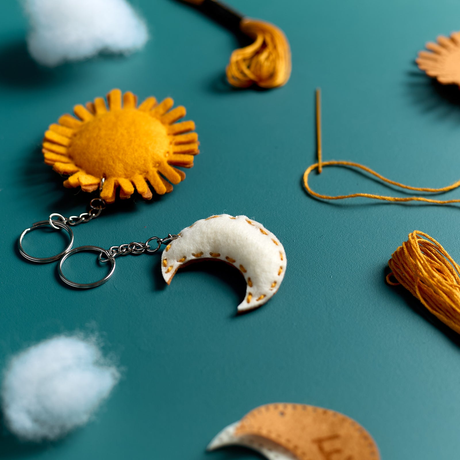Finished Sun & Moon keychains from an ODIDOMI kids craft kit displayed spread out in a close-up view.