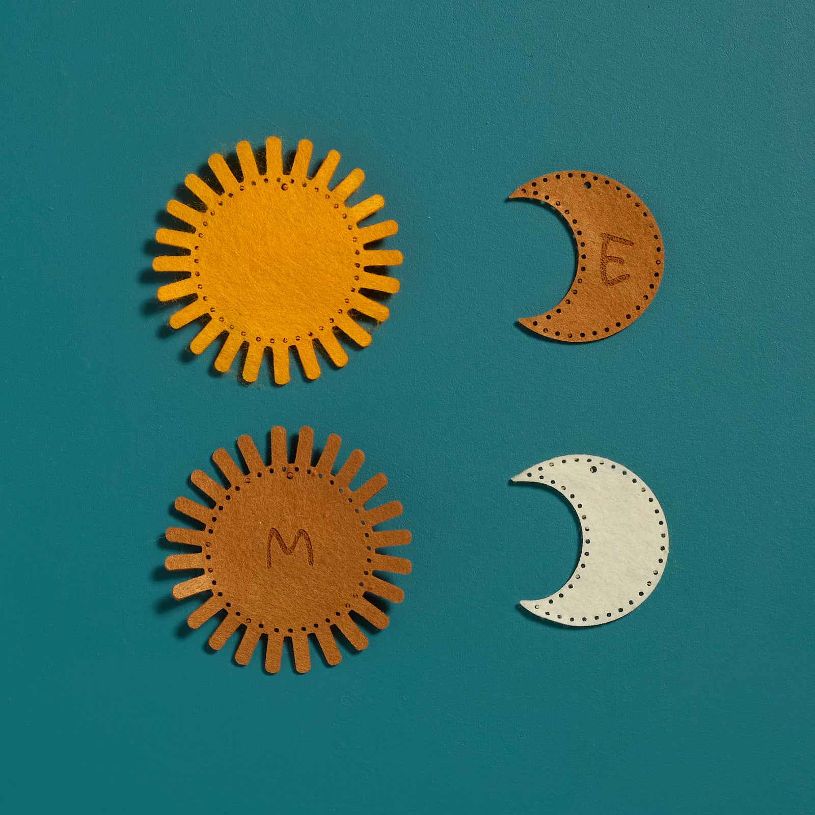Flat lay of personalized felt templates from the ODIDOMI Sun & Moon keychain craft kit.